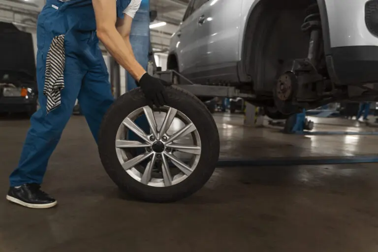 Mechaniker arbeitet am geöffneten Motorraum eines Fahrzeugs